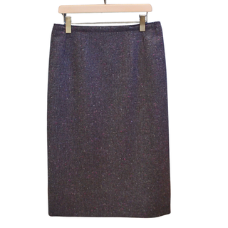 Dark denim skirt on a hanger against a white background
