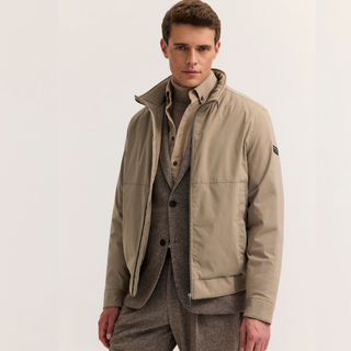 Model in beige jacket over suit on white background 