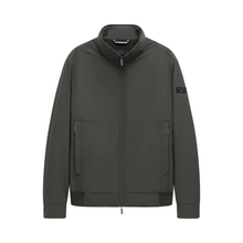 Load image into Gallery viewer, A dark olive green zip-up jacket with a stand-up collar, zippered hand pockets, and a small black rectangular logo patch on the left sleeve, shown against a plain white background.

