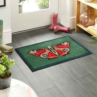 Mat at door with welly boots in background 