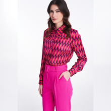 Load image into Gallery viewer, A model posing with one hand in the pocket of the Badoo Hot Pink Belted Trouser. 
