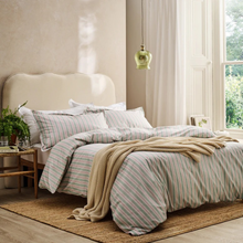 Load image into Gallery viewer, Bedroom with striped bedding and a green pendant light.
