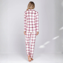 Load image into Gallery viewer, A woman viewed from behind wearing a matching long-sleeve plaid pajama set in white with red and thin black lines, standing against a light gray studio background.
