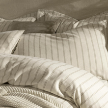 Load image into Gallery viewer, Striped bedding set with pillows and a blanket on a neutral background
