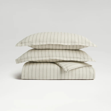 Load image into Gallery viewer, Stack of striped bedding on a light gray background
