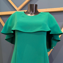 Load image into Gallery viewer, Green dress on a mannequin against a geometric-patterned wall.

