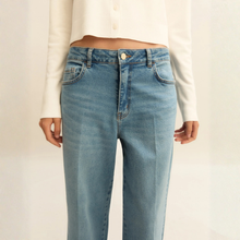 Load image into Gallery viewer, Light blue jeans worn by a person on a plain background
