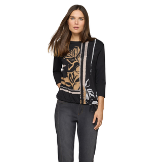 Woman wearing a black sweater with floral patterns on a white background