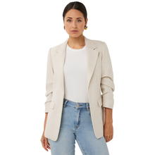 Load image into Gallery viewer, Woman wearing a beige blazer over a white shirt and blue jeans on a white background
