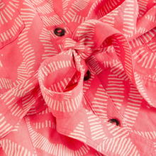 Load image into Gallery viewer, Close-up of a pink fabric with white patterns and buttons.
