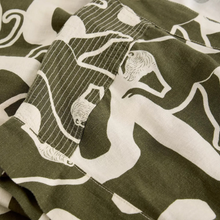 Load image into Gallery viewer, Close-up of a fabric with white abstract patterns on a green background
