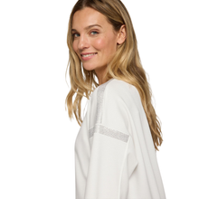 Load image into Gallery viewer, Woman wearing a white blouse with a subtle pattern on a white background
