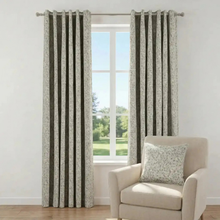 Load image into Gallery viewer, Floral patterned curtains with a chair and pillow in a room with a window.
