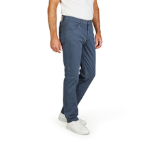 Load image into Gallery viewer, Person wearing blue jeans and white sneakers on a white background
