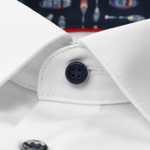 Load image into Gallery viewer, Close-up of a white shirt with a button and collar detail, with a blurred background.
