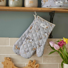 Load image into Gallery viewer, Pair of quilted oven mitts with chicken pattern hanging on a hook against a kitchen wall.

