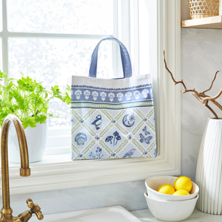 Decorative tote bag with patterns on a windowsill next to a bowl of lemons.