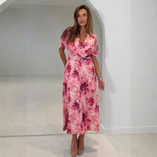 Load image into Gallery viewer, Woman wearing a pink floral dress standing in a white room.
