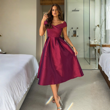Load image into Gallery viewer, Woman in a burgundy dress standing in a bedroom.
