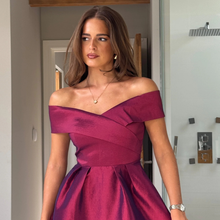Load image into Gallery viewer, Woman wearing a magenta off-shoulder dress indoors.
