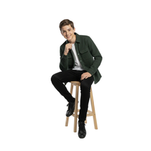 Load image into Gallery viewer, Boy sitting on a stool wearing a green shirt and black pants on a white background
