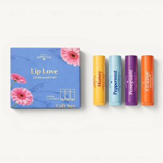 A lip balm gift set by Dublin Herbalists featuring a blue floral box labeled 'Lip Love' next to four individual lip balms in yellow, light blue, purple, and orange.