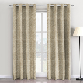 Beige curtains with grommets on a window in a room with a lamp.