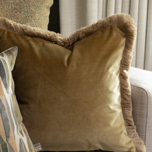 Load image into Gallery viewer, Brown velvet pillow with fringes on a sofa
