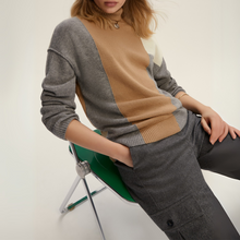 Load image into Gallery viewer, Person wearing a gray and brown sweater sitting on a green chair against a white background
