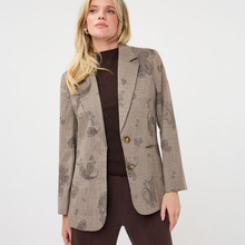 Load image into Gallery viewer, A woman wearing a brown and beige patterned blazer over a dark brown turtleneck and matching brown pants, photographed against a plain light gray studio background.
