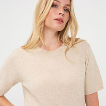 Load image into Gallery viewer, A blonde woman wearing a short-sleeve crewneck knit sweater in a light oatmeal beige color, photographed against a clean white background.
