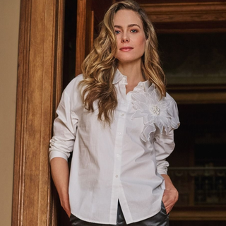 Lady in doorway wear blouse with grey trousers 