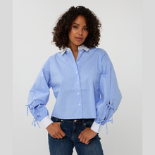 Load image into Gallery viewer, Woman wearing a light blue striped shirt with tied cuffs on a white background
