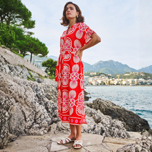 Load image into Gallery viewer, Lady by the water in red and white dress 
