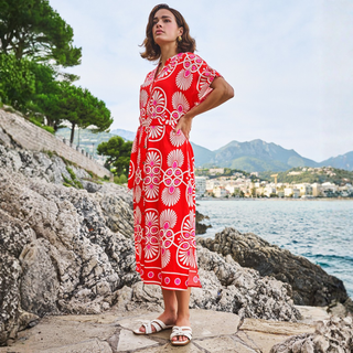 Lady by the water in red and white dress 