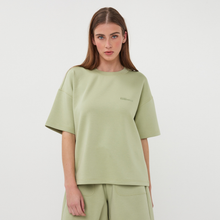 Load image into Gallery viewer, Woman wearing a light green t-shirt and pants on a white background
