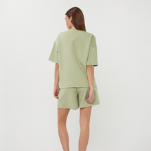 Load image into Gallery viewer, Woman wearing a light green outfit on a white background
