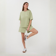 Load image into Gallery viewer, Woman wearing a light green outfit with a plain background
