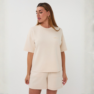 Woman wearing a beige outfit against a white background