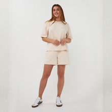 Load image into Gallery viewer, Woman wearing a beige outfit with shorts and a top on a white background

