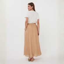 Load image into Gallery viewer, Woman wearing a white top and beige skirt on a plain background

