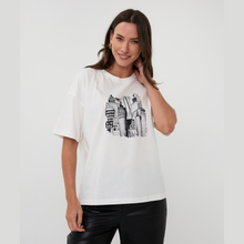 Load image into Gallery viewer, Woman wearing a white t-shirt with black graphic design on a plain background

