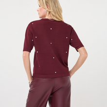 Load image into Gallery viewer, A woman shown from the back wearing a short-sleeve burgundy knit top with small white dot embellishments and matching burgundy pants, against a plain light gray studio background.
