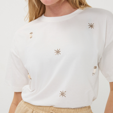 Load image into Gallery viewer, White tshirt with decorative elements on a plain background
