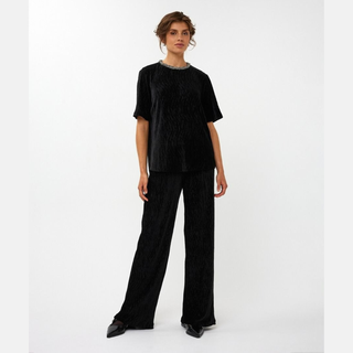 Person wearing a black outfit on a white background