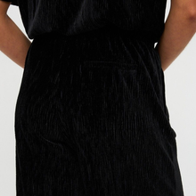 Load image into Gallery viewer, Black textured dress worn by a person on a light gray background
