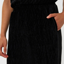 Load image into Gallery viewer, Black pleated skirt worn by a person on a white background
