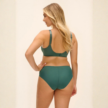 Load image into Gallery viewer, A woman modeling a two-piece swimsuit from the back, featuring a dark green bikini top and matching high-waisted bottoms, set against a plain cream-colored background.

