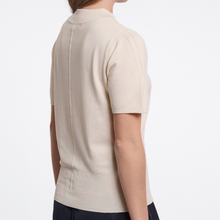 Load image into Gallery viewer, A person shown from the back wearing a short-sleeve knit top in a light warm cream or oatmeal tone, photographed against a clean white studio background.
