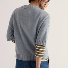 Load image into Gallery viewer, A woman shown from the back wearing a light gray knit cardigan with olive green and cream horizontal stripes on the underarms and cuffs, paired with blue jeans against a plain off-white background.
